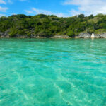 Clear turquoise water with green island in the background