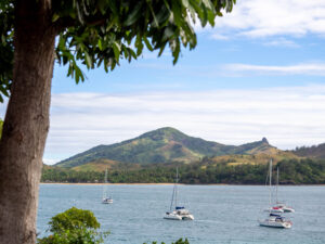 4 sailboats on the water with hills in the background