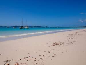 Beach foreground with sailboats on the horizon